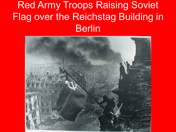 red army troops raising soviet flag over the reichstag building in berlin