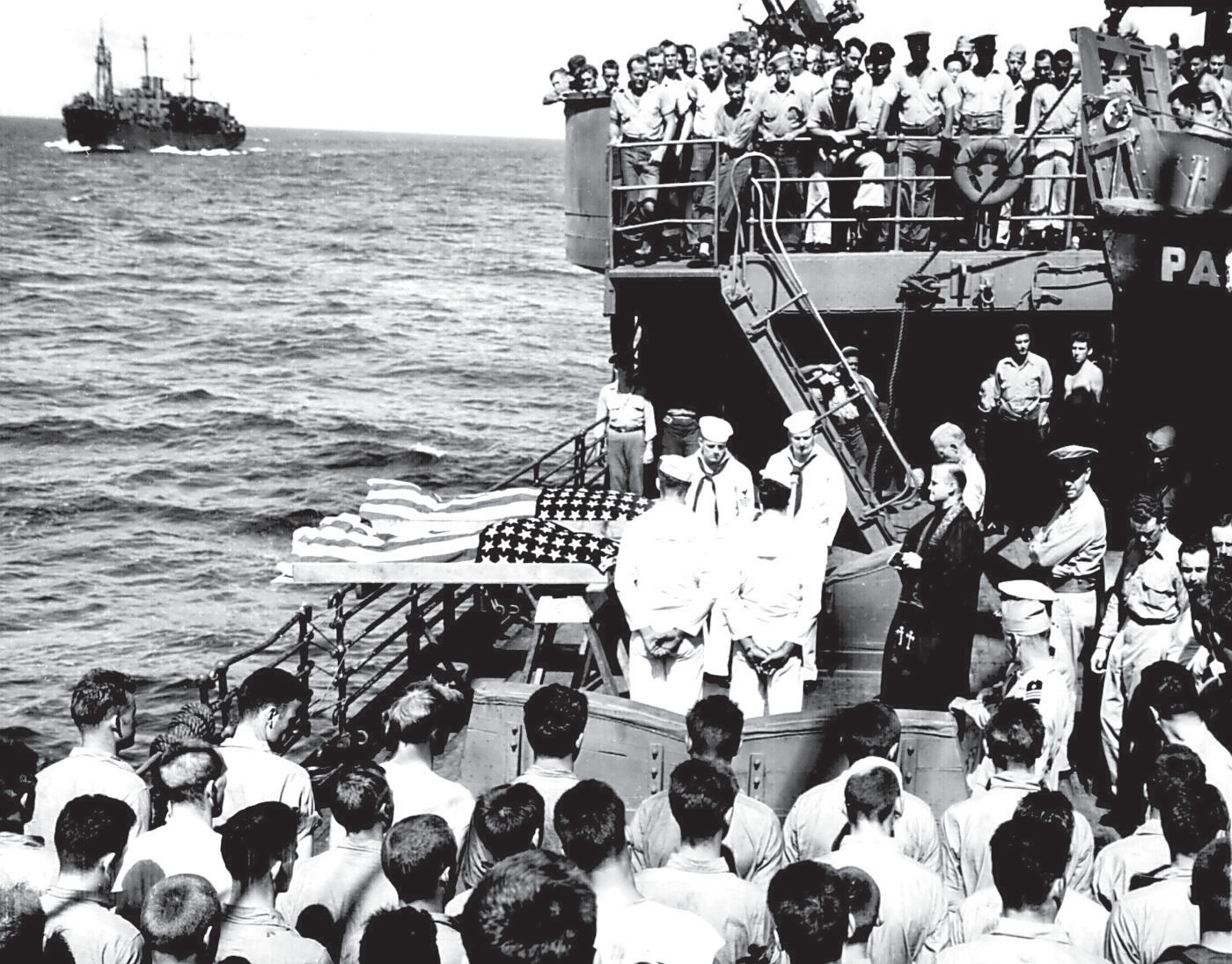 Two enlisted men of the illfated U.S. Navy aircraft carrier LISCOME BAY, torpedoed by a Japanese submarine in the Gilbert Islands, are buried at sea from the deck of a Coast Guard-manned assault transport. 