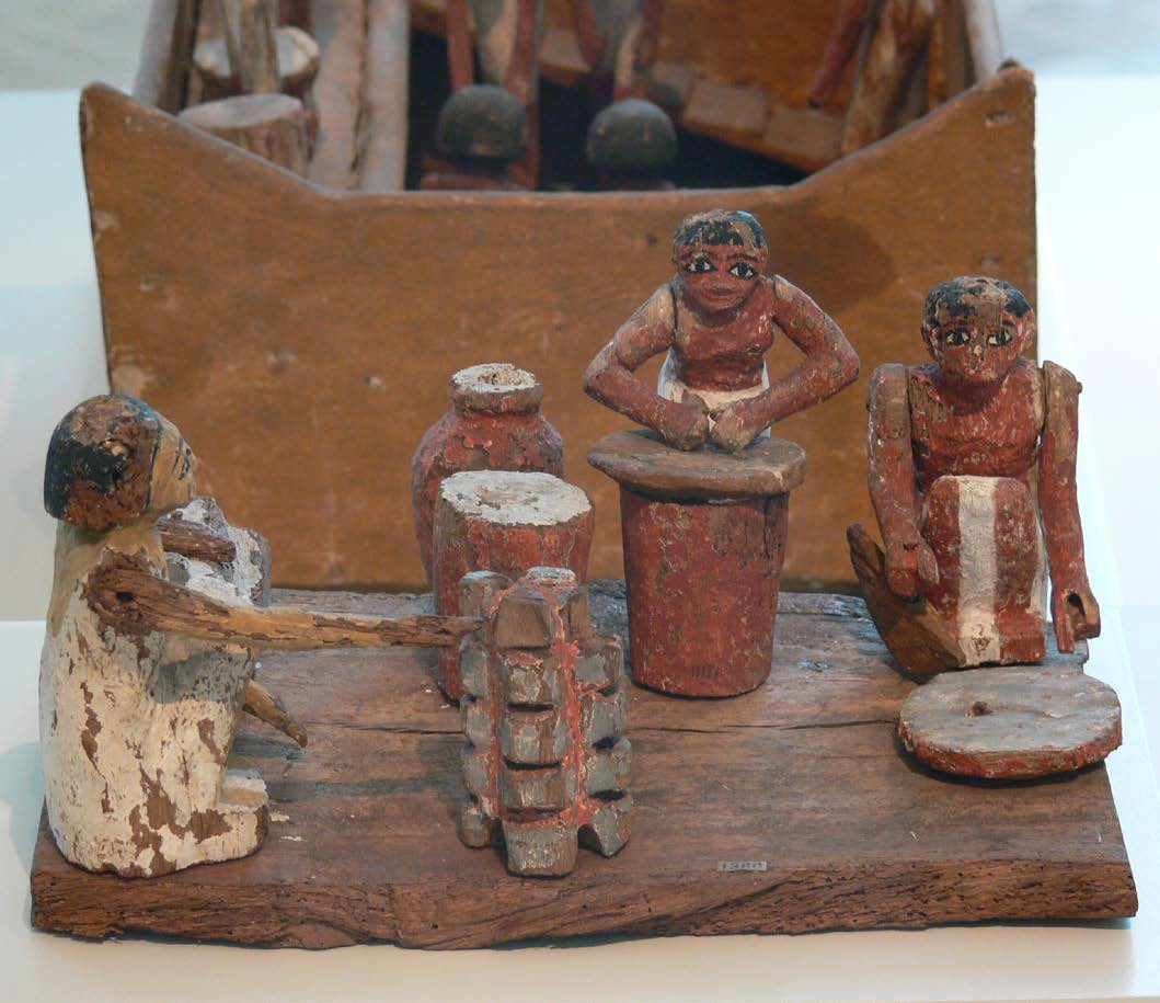 Female figurines from ancient Egypt made of clay or wood. The figurines are performing everyday tasks such as making bread and beer.