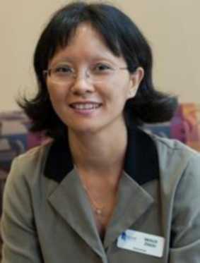 A headshot of Molly Zhou. She wears a collared jacket and glasses, and smiles at the camera.