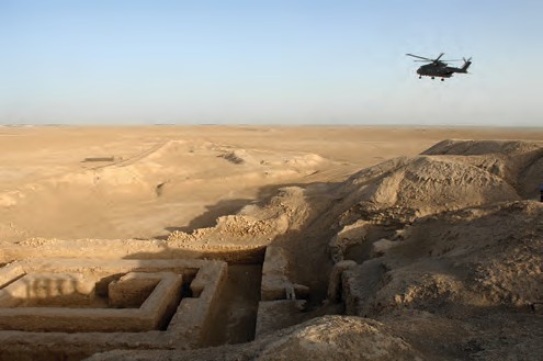 A helicopter flying over a desert Description automatically generated