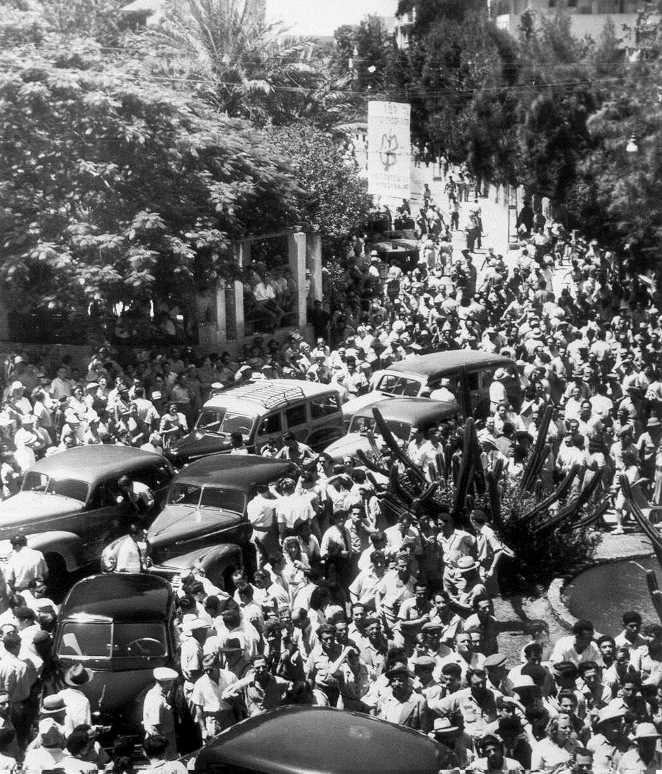 A protest against the UNSCOP, a crowd gathering around members' cars