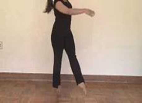 A woman stands on her toes.