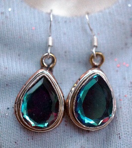 A photograph of expensive-looking emerald earrings.