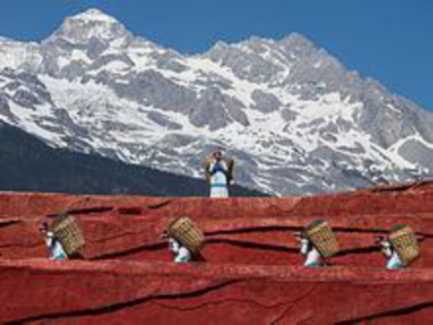 In front of a large mountain is a man standing over a line of men carrying barrels on their backs.