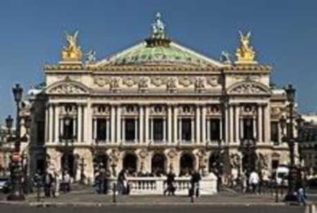 A large building with a green top and two yellow statues on the top sides. It is called the Palais Garnier of the Paris Opera.