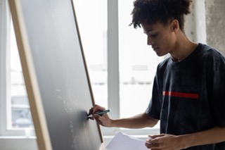 a man writing on a board