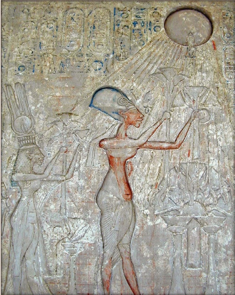 Image carved into stone showing the adoration scene of Aten with a man and a woman holding flowers up towards the sun.