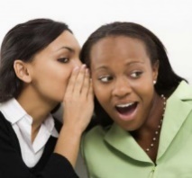 a woman whispering something to another woman