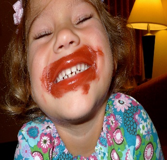 a child with red lipstick all over her face