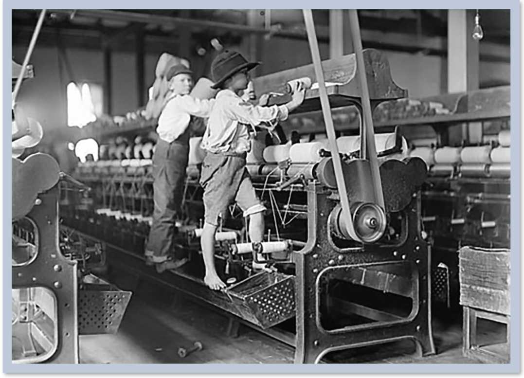 Children working at machines that are taller than them. They stand on ledges to reach the top of the equipment.